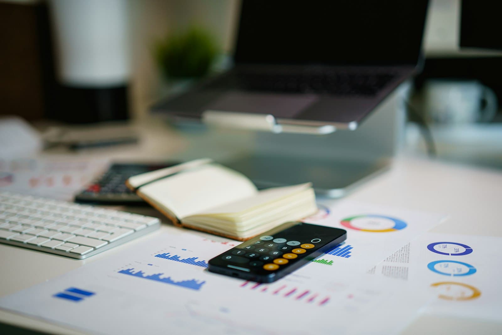 A smartphone and financial paperwork on a desk.