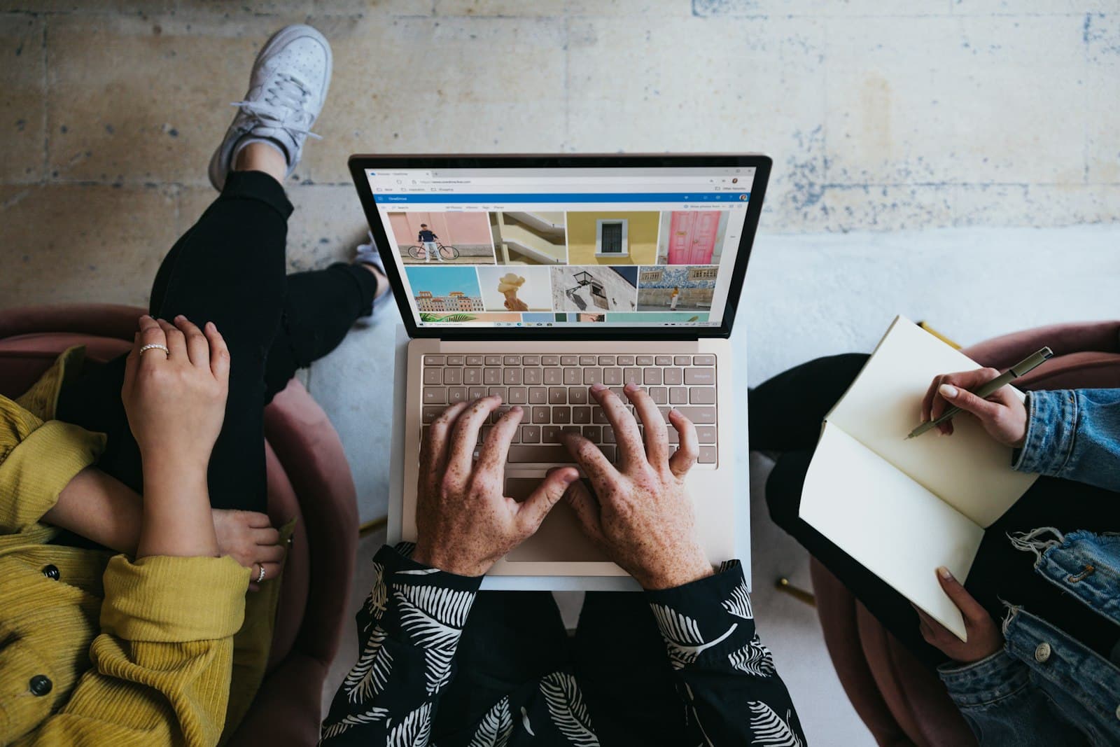A person working on a laptop together with colleagues.